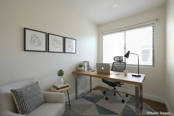 a view of a workspace with furniture and a window