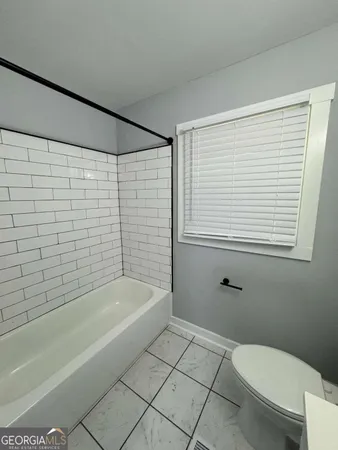 a bathroom with a toilet and a bathtub