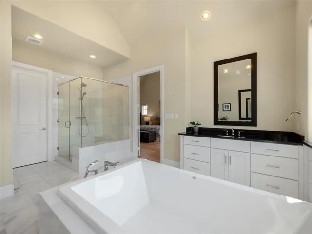 a spacious bathroom with a shower sink and mirror