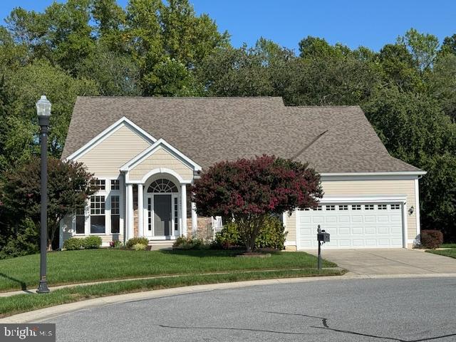 a view of a white house next to a yard and large trees