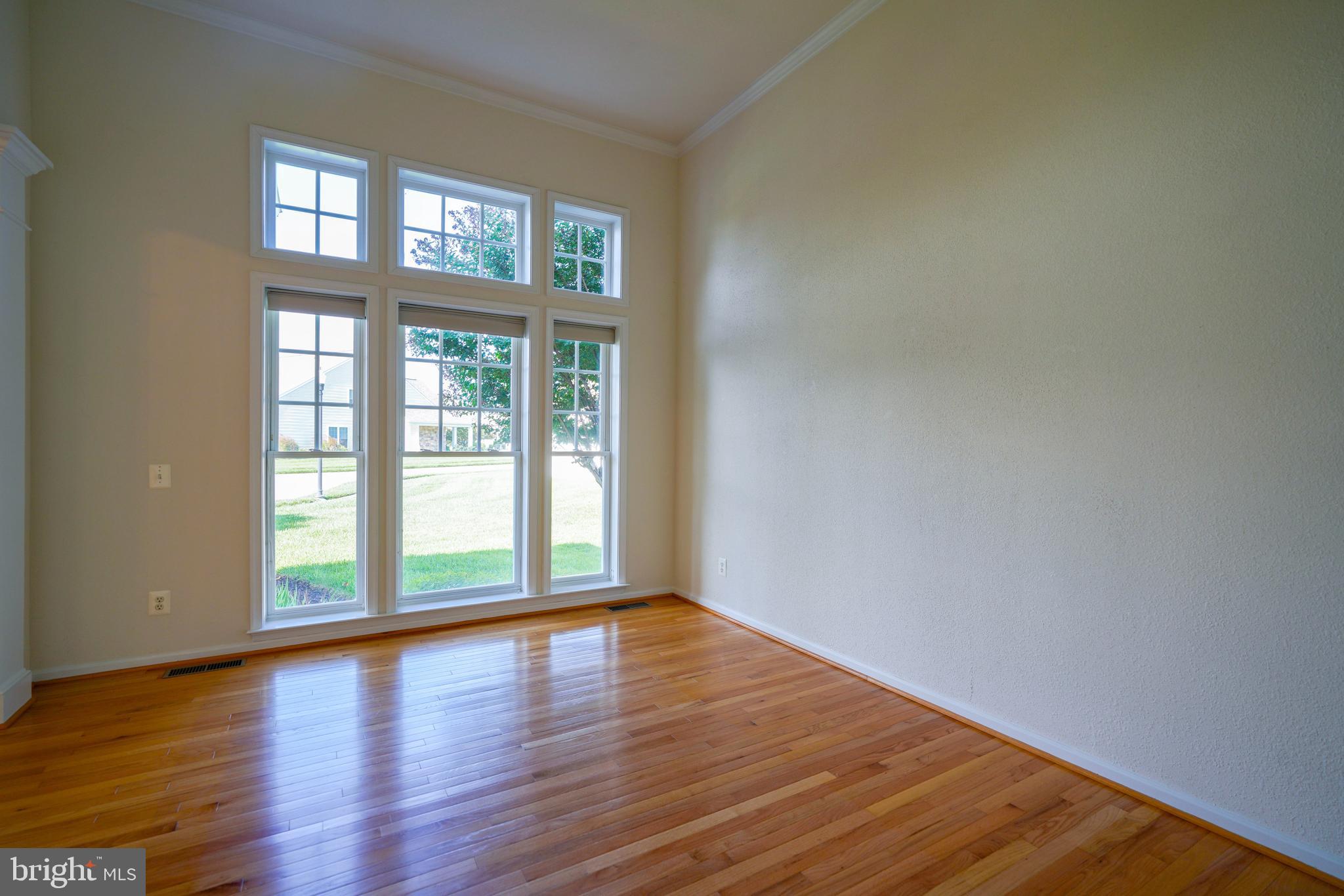 34953 Compass Cove Lewes, DE 19958 - Photo 40 of 90 a view of an empty room with wooden floor and a window
