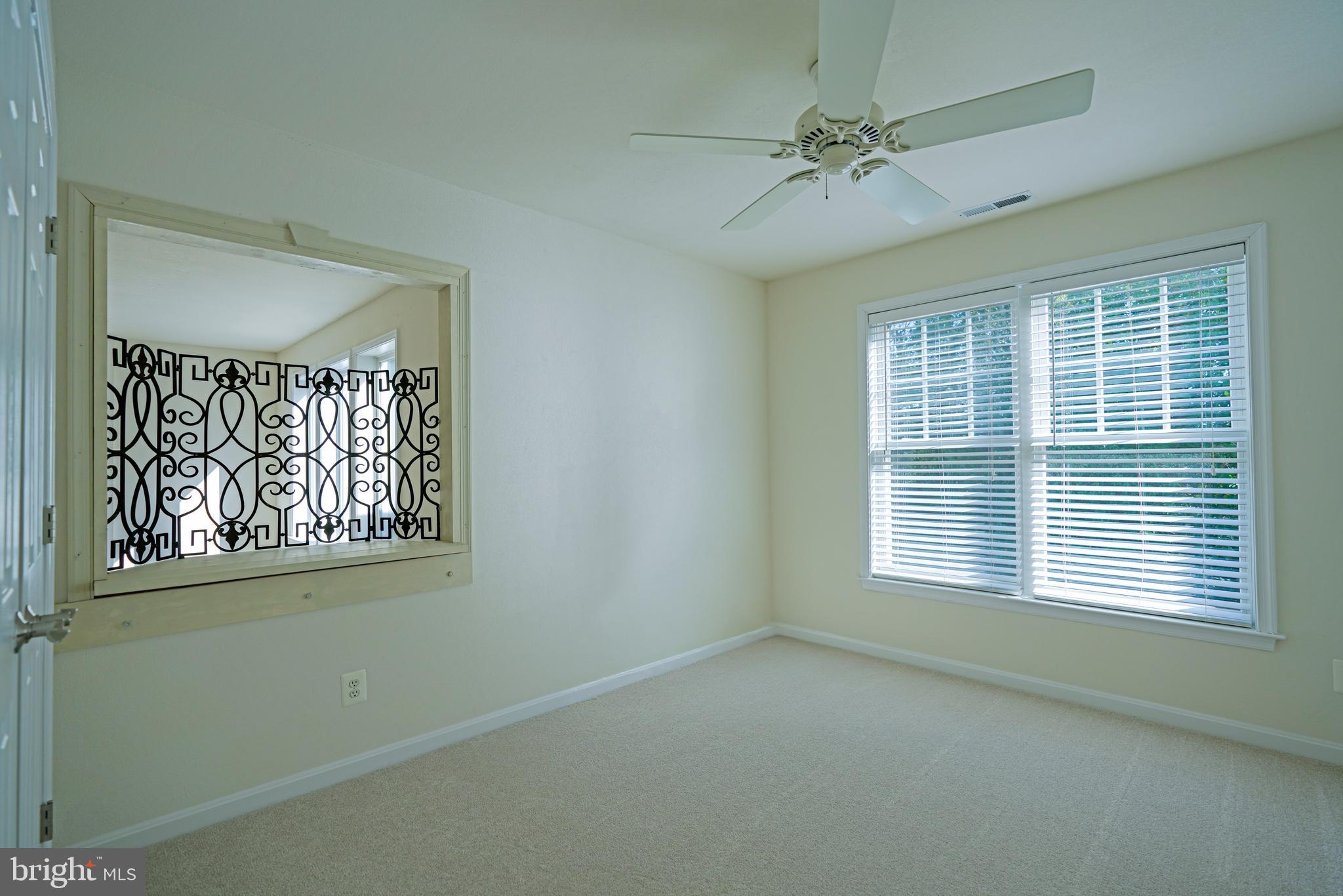 34953 Compass Cove Lewes, DE 19958 - Photo 54 of 90 an empty room with a window and a fan