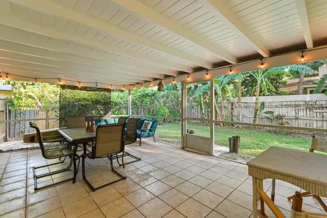 a view of a patio with table and chairs next to a yard