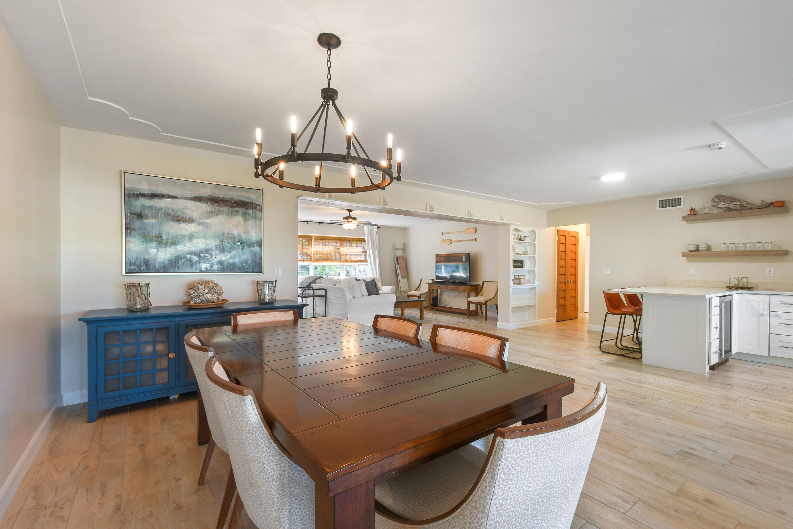 108 Norfolk Road Jupiter, FL 33469 - Photo 9 of 23 a dining room with wooden floor a chandelier a wooden table and chairs