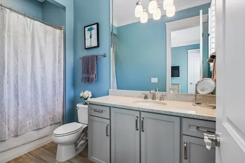 a bathroom with a sink vanity mirror and toilet