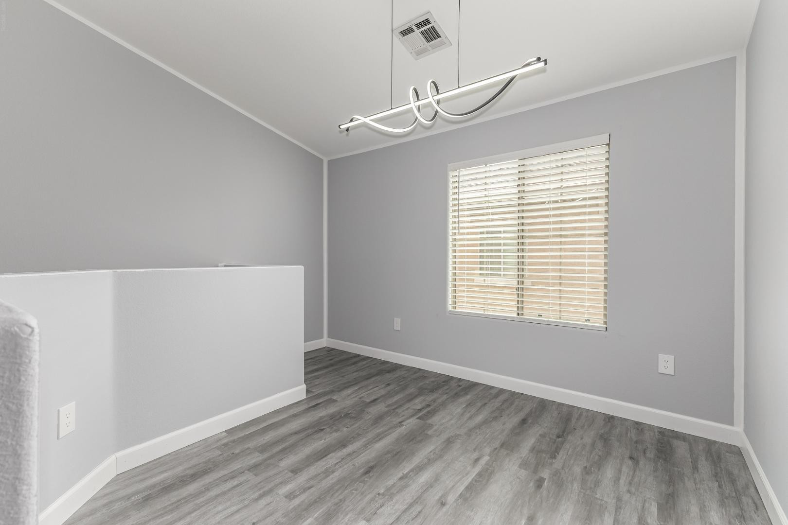 1350 South Greenfield Road, Unit 2205 Mesa, AZ 85206 - Photo 9 of 42 a view of an empty room with wooden floor and a window