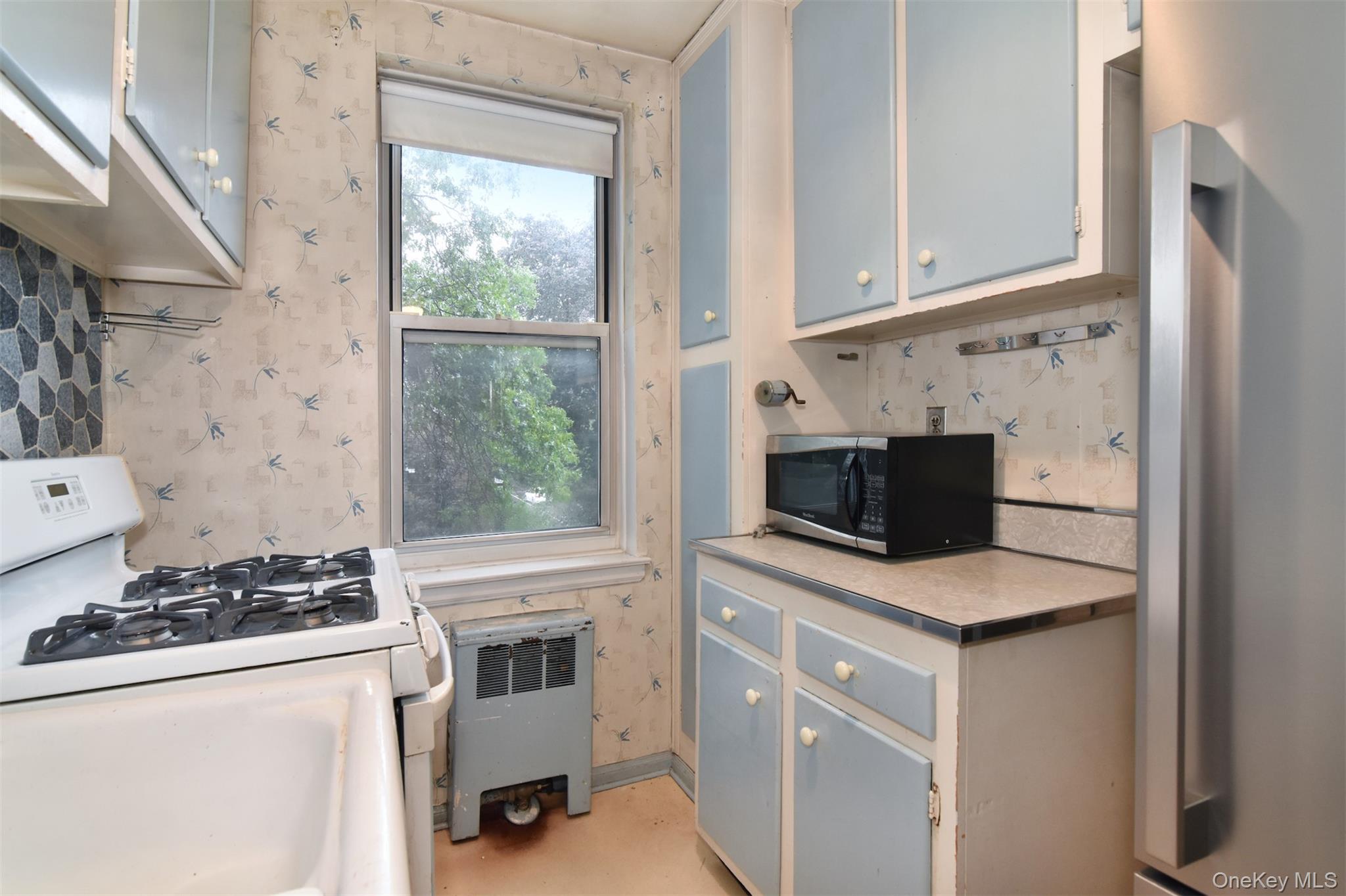 1 Georgia Avenue, Unit 3E Bronxville, NY 10708 - Photo 7 of 13 a kitchen with stainless steel appliances granite countertop a stove and a microwave