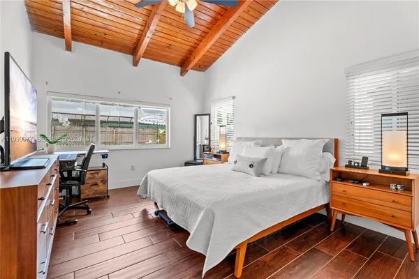 a bedroom with a bed wooden floor and window