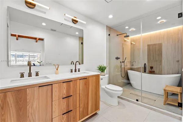 a bathroom with a double vanity sink toilet and mirror