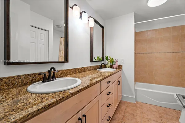 a bathroom with a granite countertop sink and a mirror