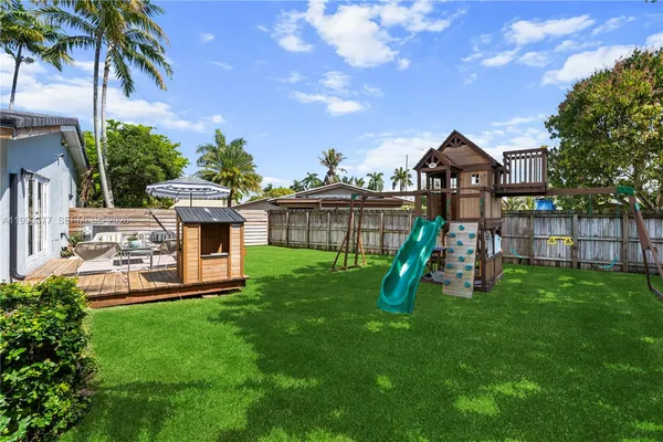 a view of a house with a backyard and a slide