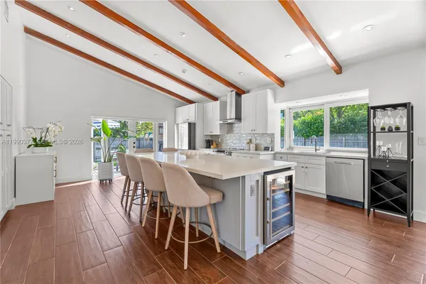 a kitchen with a table chairs a sink and dishwasher a stove with wooden floor