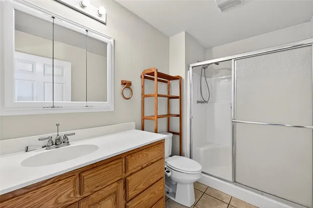a view of an empty room with window and chandelier fan