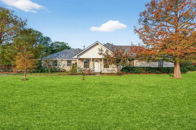 a front view of a house with a yard and trees