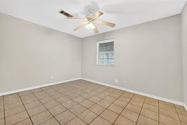 a view of an empty room and chandelier fan