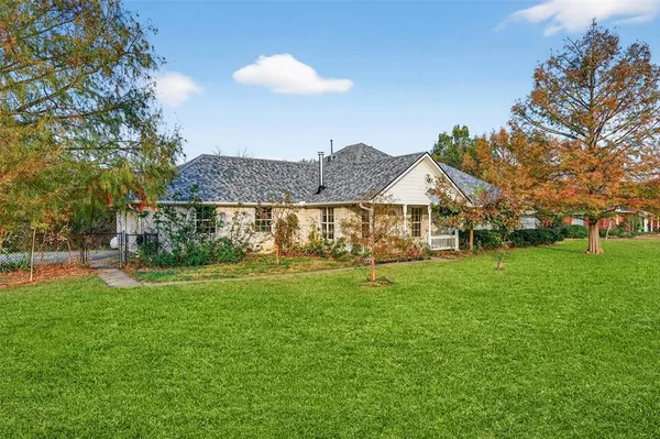 a front view of a house with a yard table and trees