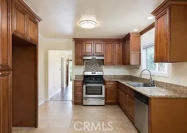 a kitchen with granite countertop a sink stainless steel appliances and cabinets