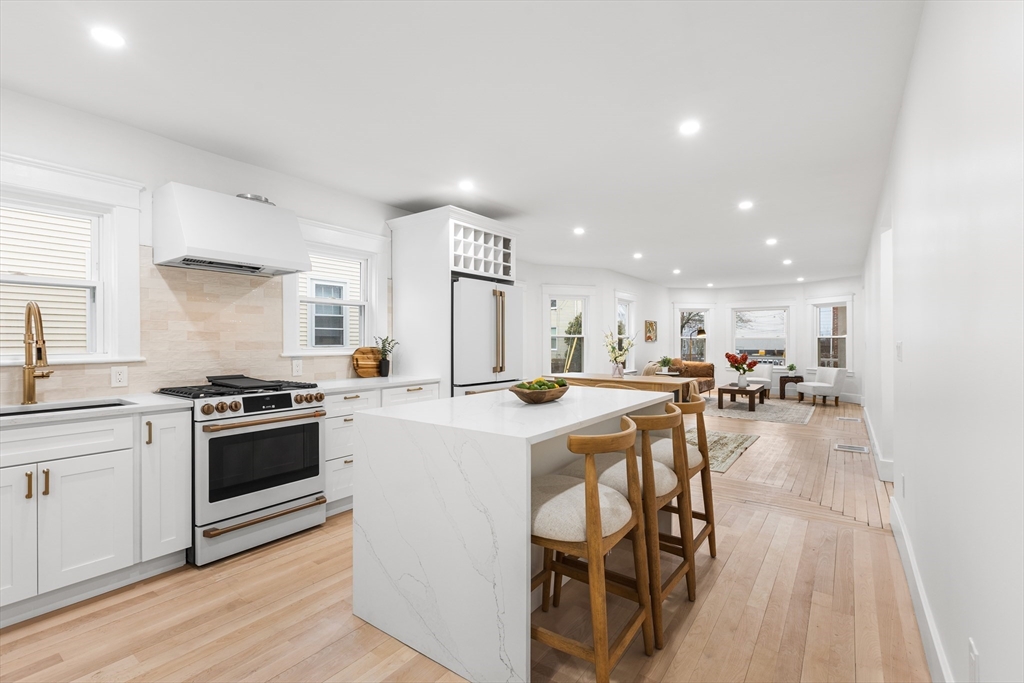 a kitchen with a sink a stove and chairs