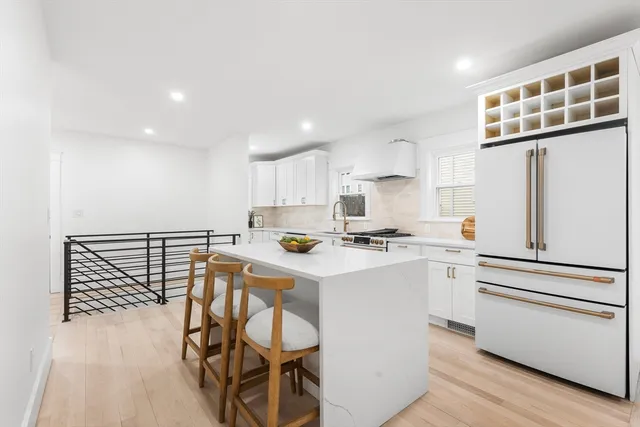 a kitchen with a sink a stove cabinets and wooden floor