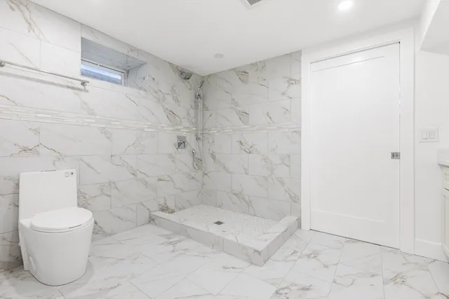 a bathroom with a toilet and a shower