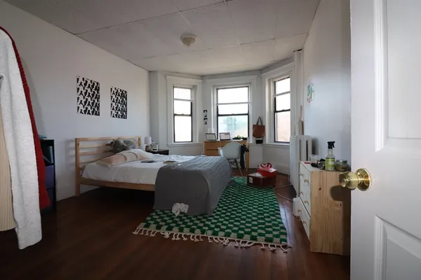 a bedroom with a bed dresser and a window