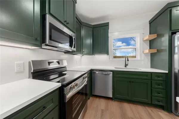 a kitchen with stainless steel appliances a stove sink and microwave