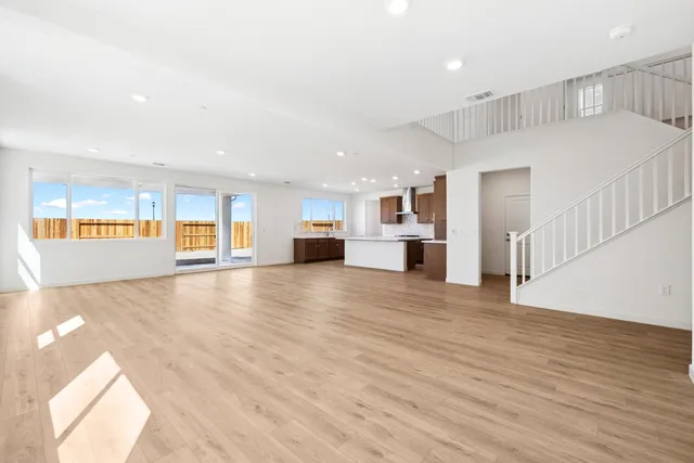 a view of a living room a kitchen with a sink and a large window