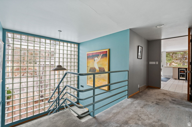1856 Fort Canyon Road Alpine, UT 84004 - Photo 3 of 49 Staircase with glass block wall, metal railing, and carpeted treads