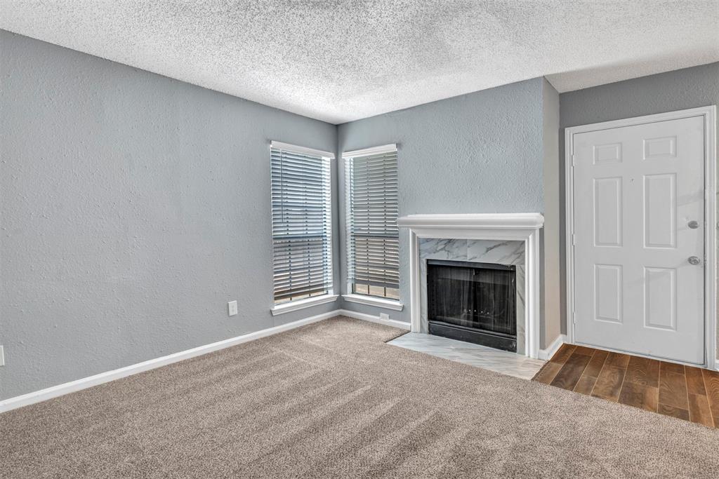 11311 Audelia Road, Unit 221 Dallas, TX 75243 - Photo 4 of 22 a view of an empty room with a fireplace and a window