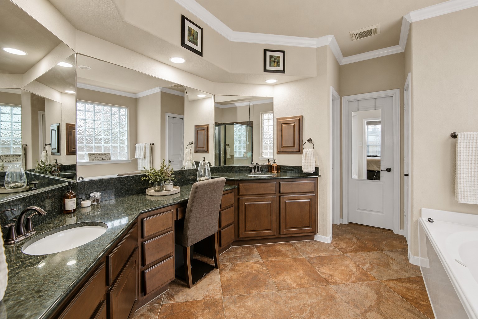 6007 Valhalla Drive Spring, TX 77379 - Photo 18 of 36 The spa-inspired primary ensuite features dual sinks, vanity seating, a soaking tub, and separate glass-enclosed shower.