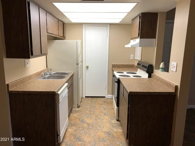 a kitchen with a sink stove and a refrigerator