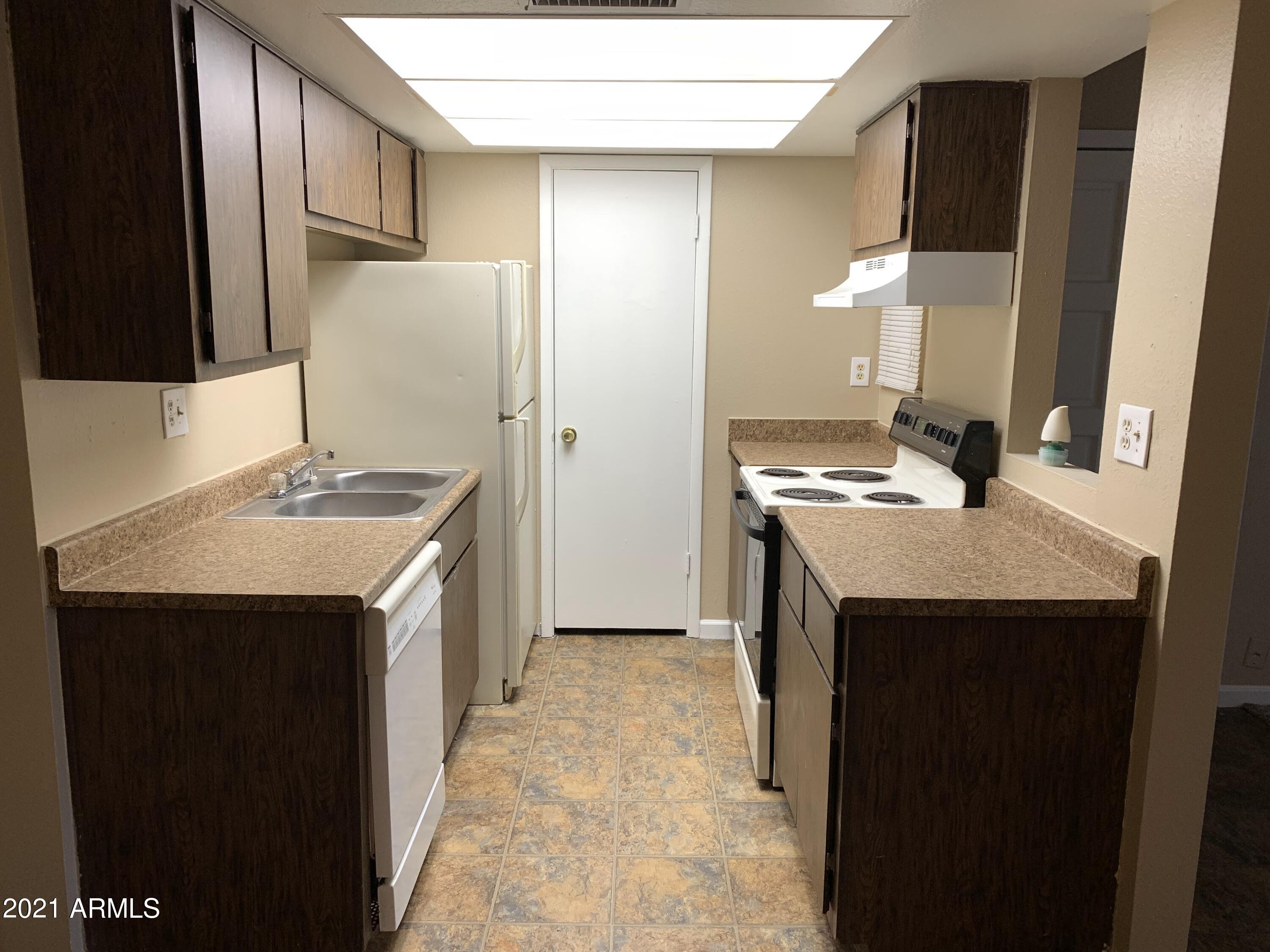 2217 East Cactus Road, Unit 4 Phoenix, AZ 85022 - Photo 5 of 14 a kitchen with a sink stove and a refrigerator