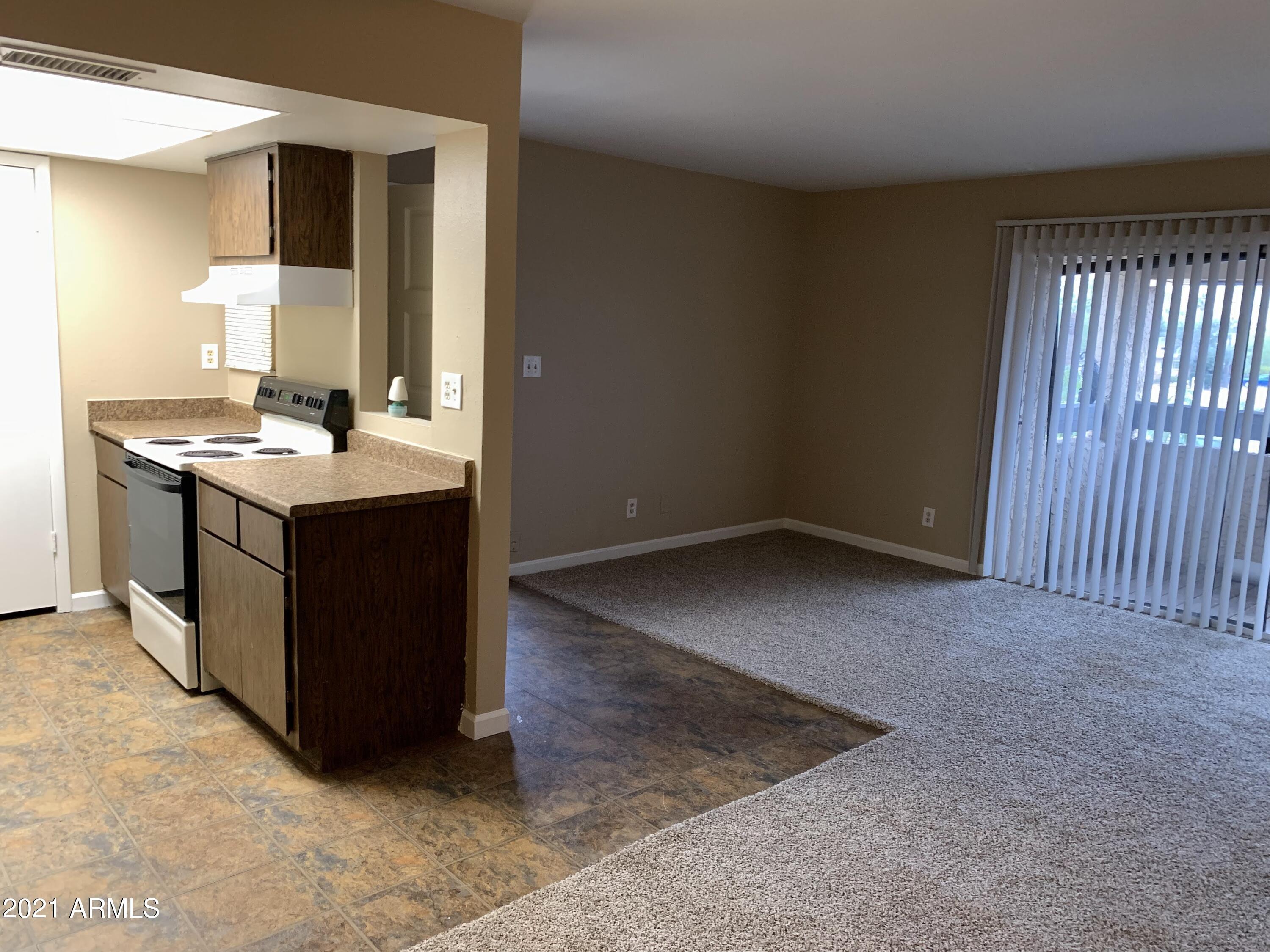 2217 East Cactus Road, Unit 4 Phoenix, AZ 85022 - Photo 6 of 14 an empty room with a kitchen