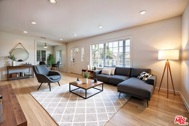 a living room with furniture and a wooden floor