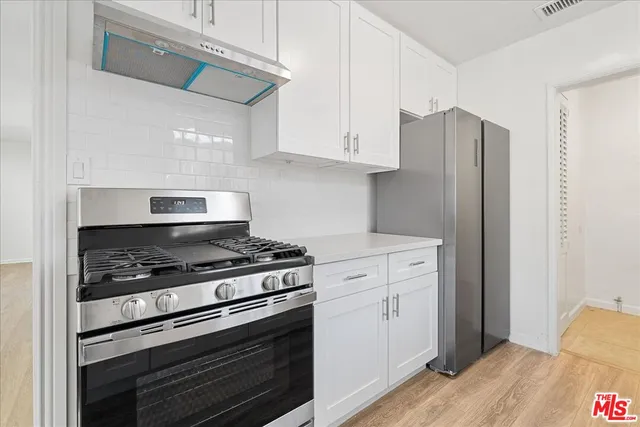 a kitchen with stainless steel appliances white cabinets and a stove