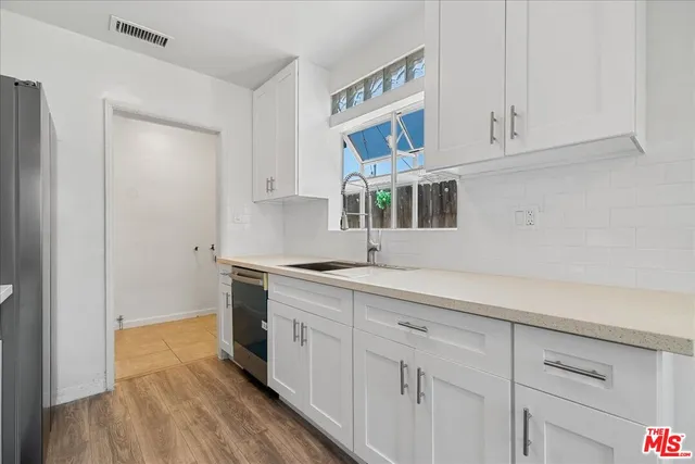 a kitchen with cabinets and wooden floor