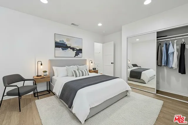 a bedroom with a bed and wooden floor