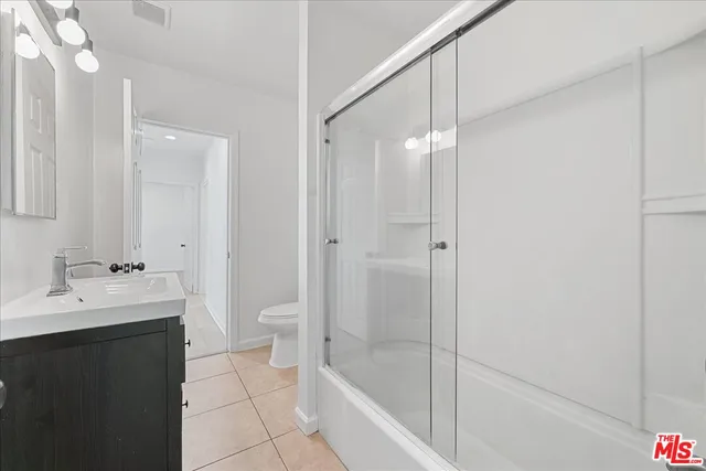 a bathroom with a bathtub shower sink vanity and toilet