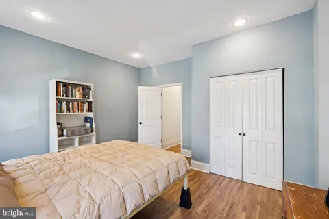 a bedroom with a large bed and a wooden floor
