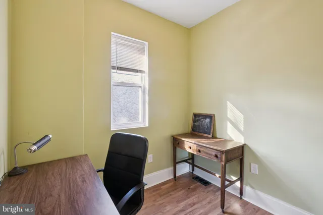 a view of a workspace with furniture and wooden floor