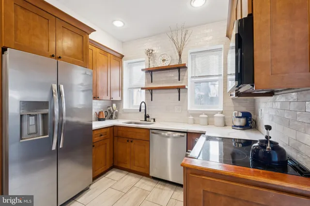 a kitchen with stainless steel appliances a refrigerator sink and cabinets