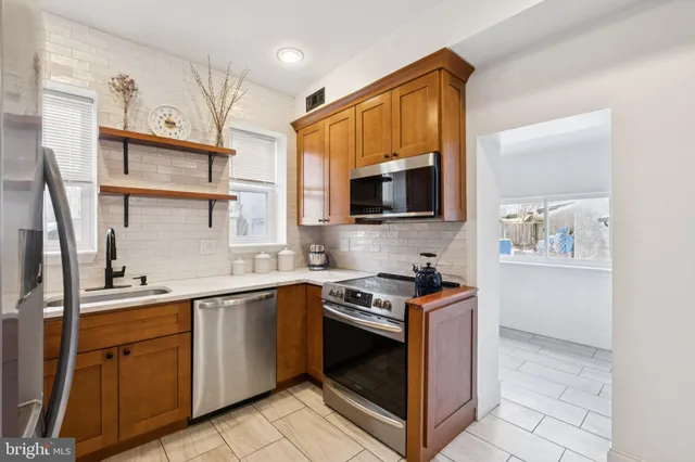 a kitchen with stainless steel appliances a sink stove and microwave