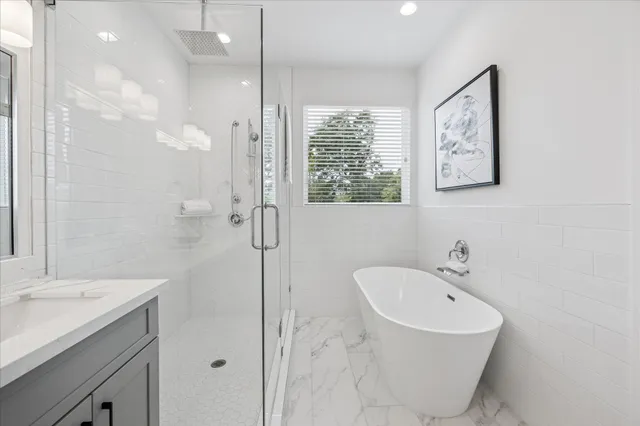 a bathroom with a tub sink and mirror