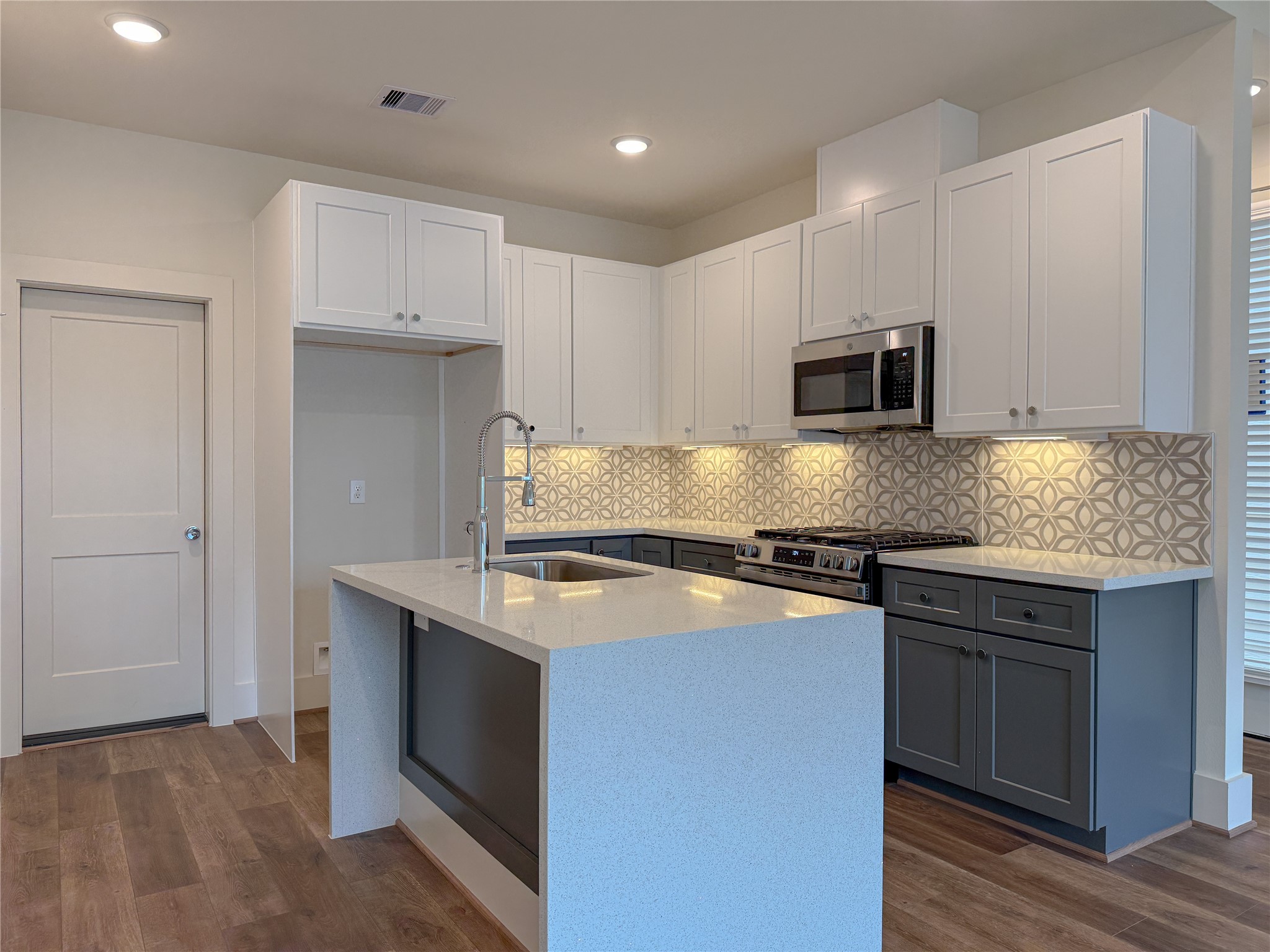 879 Rachel Street, Unit F Houston, TX 77091 - Photo 5 of 23 a kitchen with stainless steel appliances granite countertop a stove a sink and a microwave