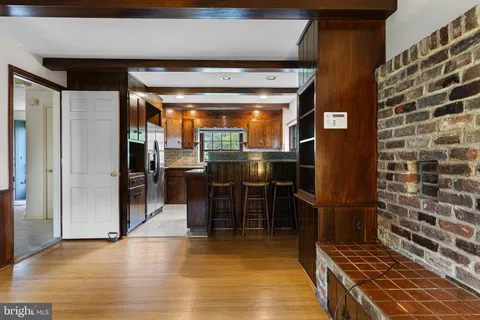 a kitchen with stainless steel appliances granite countertop a table chairs and a refrigerator