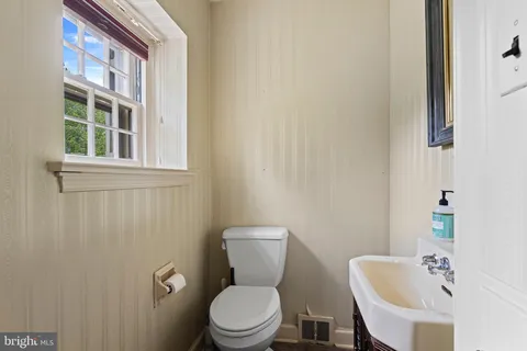 an empty room with windows and fireplace