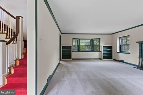 a view of a big room with wooden floor and windows