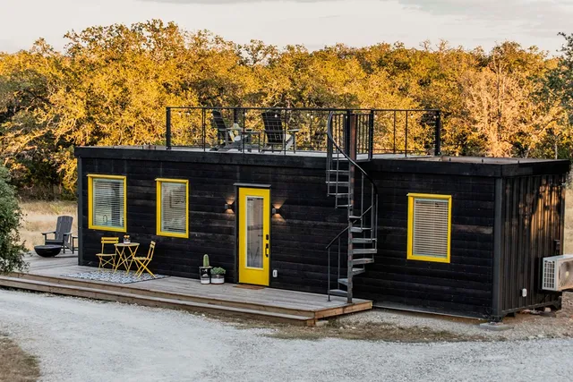 a view of a lake from a balcony with chairs