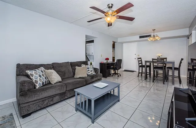 a living room with furniture a ceiling fan and a rug