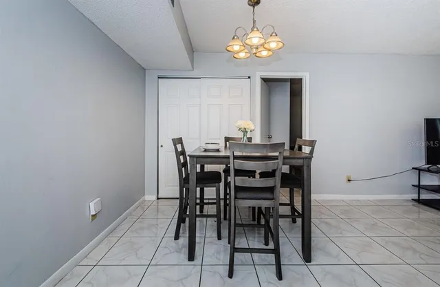a view of a dining room with furniture and chandelier